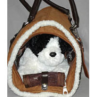 A toy dog in the Berber Carrier showing the mesh side panel secured with a snap.